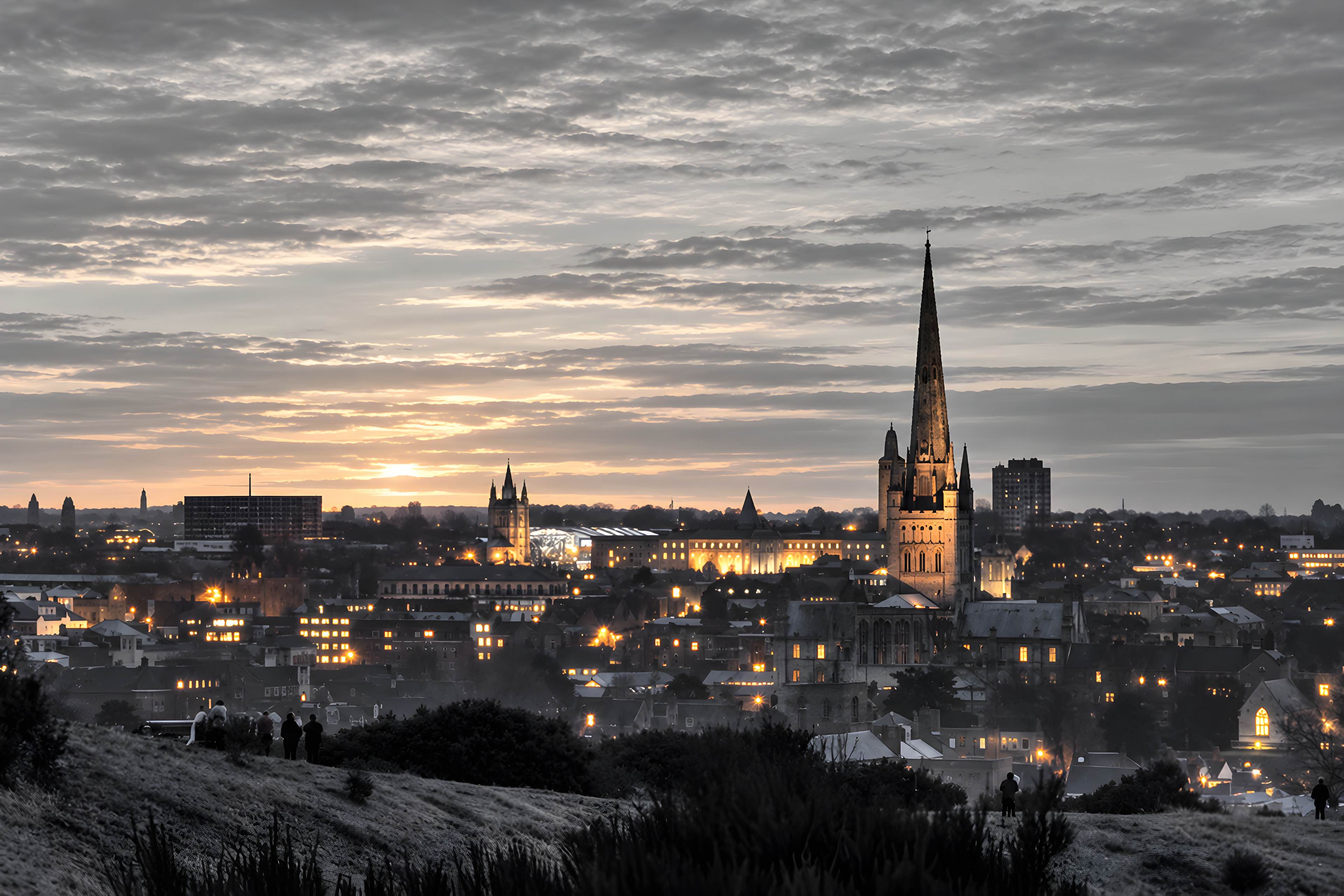 The Norwich skyline at dusk, with the cathedral spire lit up